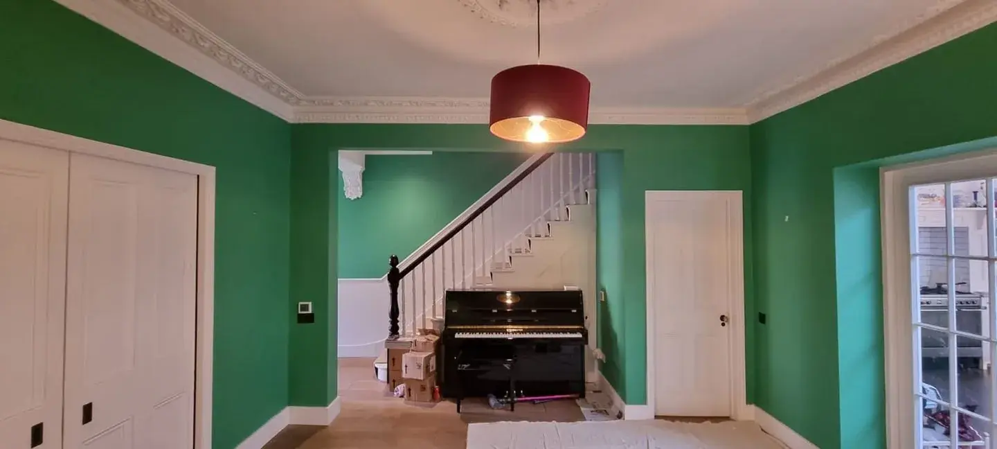 Freshly painted period living room in West London with restored ornate cornicing and staircase